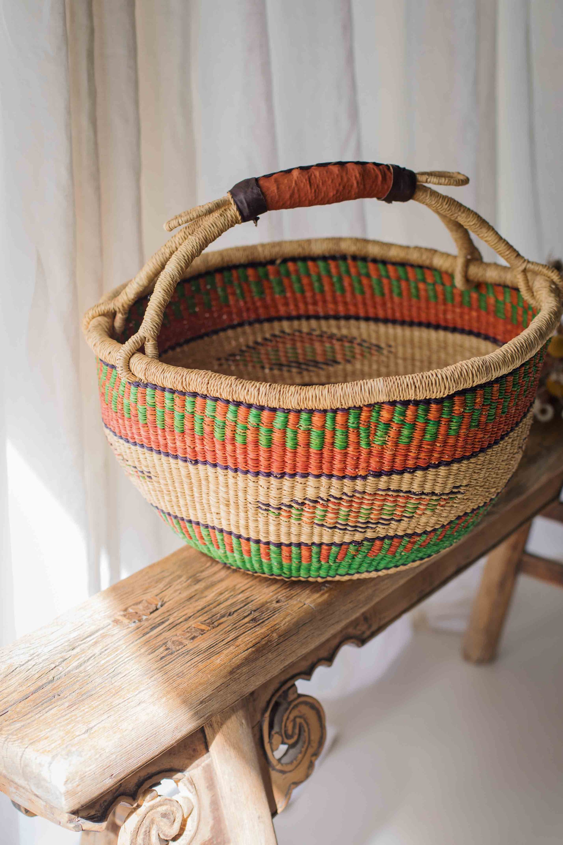 Woven basket with colorful patterns on a wooden surface